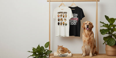 Animal Obsessed graphic tees on a rack and folded on a bench with a cat and a dog